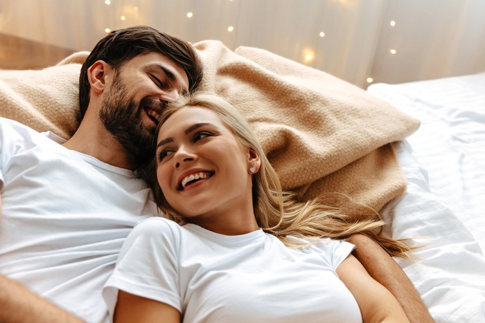 ilustrasi pasangan Love. Fun. Emotions. Young couple are laughing while lying together on the bed