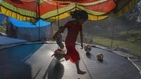Permainan trampolin yang disukai anak-anak, di Dharasala, India, Selasa (22/3/2022). Permainan fisik yang menggerakkan seluruh jaringan badan menjadi salah satu alasan untuk lebih riang dan rileks. (AP Photo/Ashwini Bhatia)