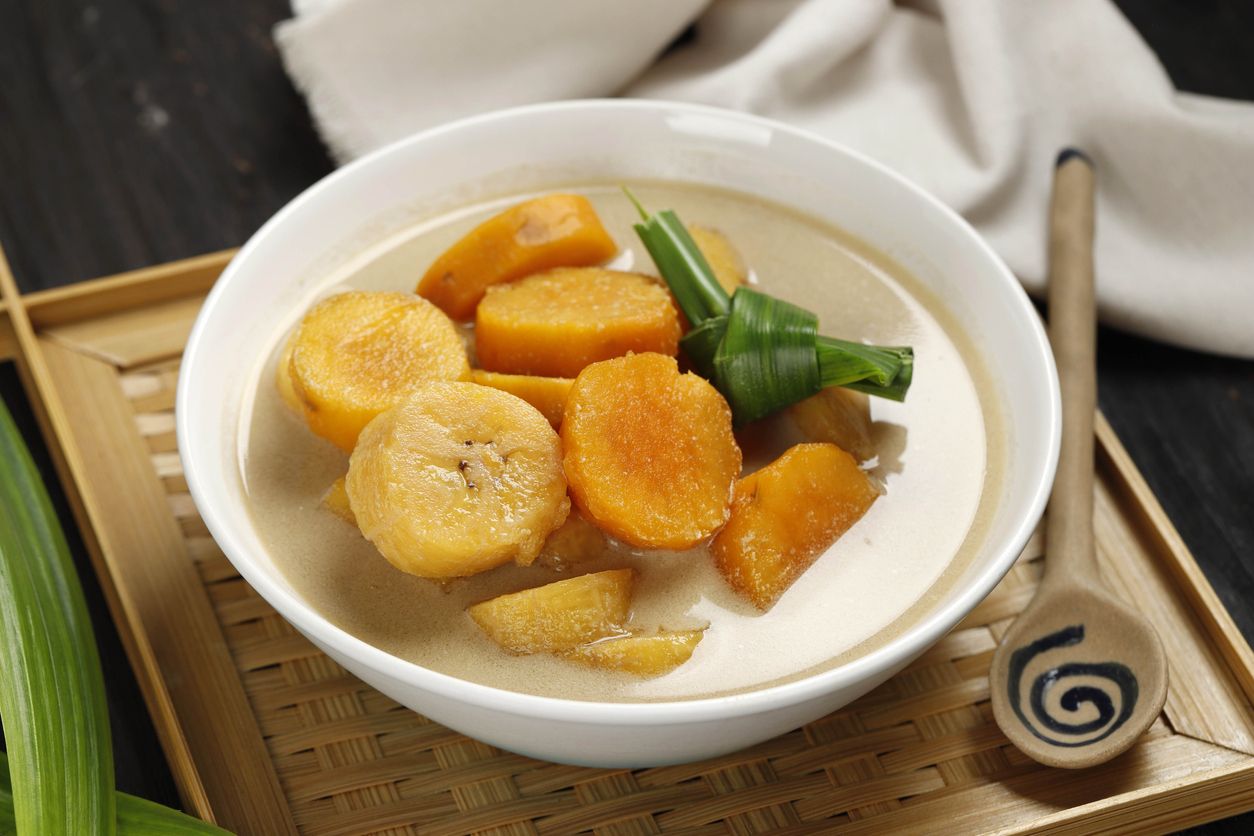 Kolak Pisang Ubi, Indonesian Popular Dessert for Takjil Ramdan Breaking the Fast, Sweet Soup Made from Banana and Sweet Potato, on Wooden Table