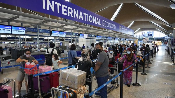 Sejumlah pelancong mengantre di konter check-in Bandara Internasional Kuala Lumpur, Sepang, Malaysia, Jumat (1/4/2022). Diketahui, Malaysia membuka kembali perbatasannya untuk wisawatan asing mulai hari ini.