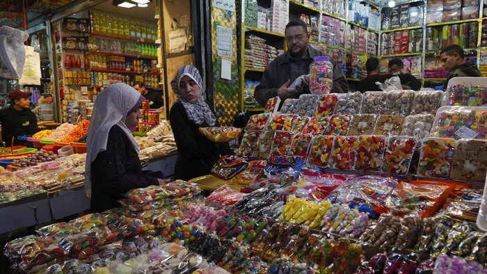 Melihat Kesibukan Pasar di Gaza Jelang Ramadan People, some wearing masks to help prevent the spread of the coronavirus, shop for the Muslim holy month of Ramadan, at al-Zawya traditional market in Gaza City, Thursday, March 31, 2022. As Ramadan begins with the new moon next week, Muslims around the world are trying to maintain their religious rituals of Islamic holiest month. (AP Photo/Adel Hana)