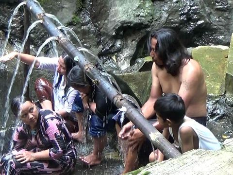 Warga mandi di bawah pancuran air hangat di Desa Gumelem Wetan, Kecamatan Susukan.