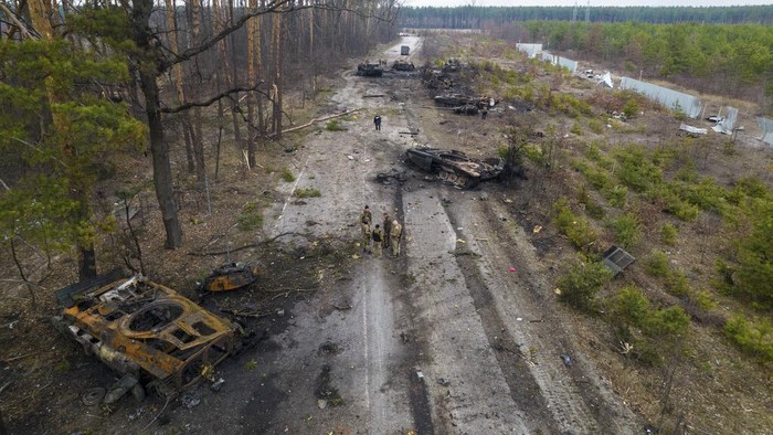 Ukrainian soldiers pass on top of an armored vehicle next to destroyed Russian tanks in the outskirts of Kyiv, Ukraine, Thursday, March 31, 2022. Russian forces shelled Kyiv suburbs, two days after the Kremlin announced it would significantly scale back operations near both the capital and the northern city of Chernihiv to “increase mutual trust and create conditions for further negotiations.” (AP Photo/Rodrigo Abd)