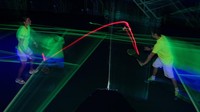 Lapangan bulu tangkis Malaysia itu berhias lampu neon di lantai dan dinding, ketukan elektronik yang berdenyut, dan shuttlecock merah menyala memantul bolak-balik.   