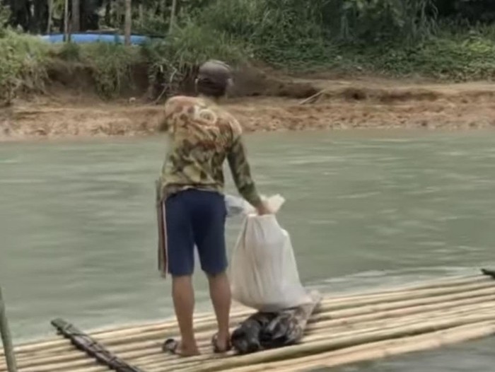 Warga Desa Belawae memakai rakit bambu untuk menyeberang.