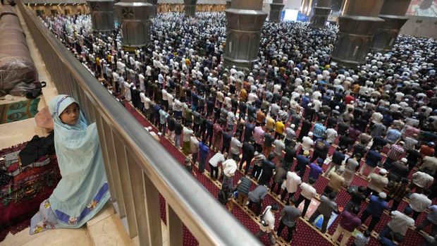 A little girl looks on during an evening prayer on the eve of the holy fasting month of Ramadan at Istiqlal Mosque in Jakarta, Indonesia, Saturday, April 2, 2022. (AP Photo/Dita Alangkara)