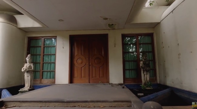Pintu utama diapit oleh dua kolam. Kolam sisi kiri dihiasi sebuah patung. (Foto: YouTube/Papi Story)