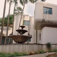 YouTuber bernama Papi Story mendokumentasikan kunjungannya ke sebuah rumah mewah yang sudah tak bertuan. Tampak depan, rumah tersebut seperti bangunan berarsitekur futuristik 90-an yang unik karena penuh lekukan pada sudut-sudutnya. (Foto: YouTube/Papi Story)