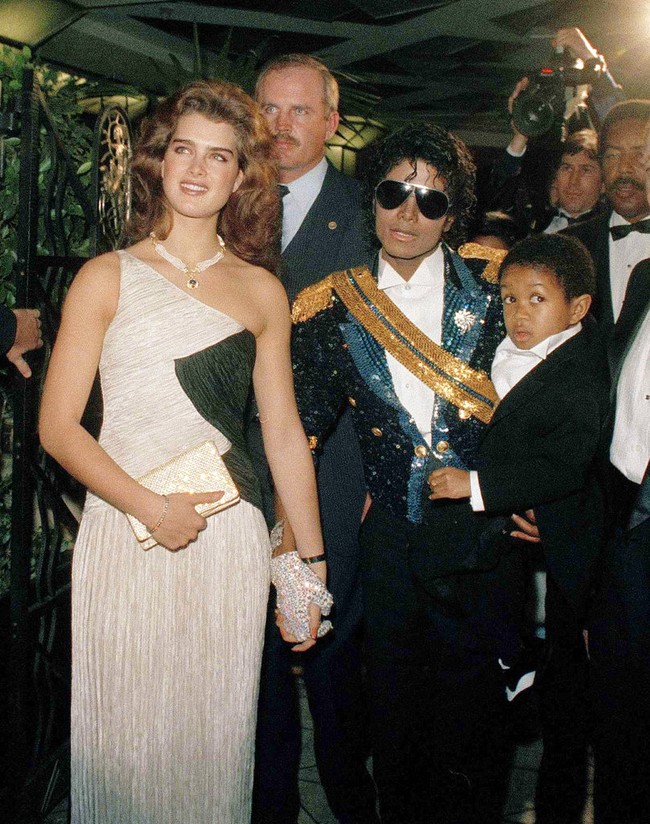 Michael Jackson sedang naik daunnya sebagai penyanyi solo saat menghadiri Grammy Awards 1984. Sorotan pun tertuju padanya yang kala itu menggandeng aktris dan model Brooke Shields muda. Sebagai ikon gaya, ia memilih setelan berkilauan dengan sentuhan elemen militer yang didesain khusus oleh perancang kostum Michael Bush. Menurut Bush, kliennya terinspirasi oleh pakaian bangsawan Inggris. Di ajang tersebut, ia memecahkan rekor dengan meraih delapan piala Grammy dari 12 nominasi. (Foto: AP/Reed Saxon)