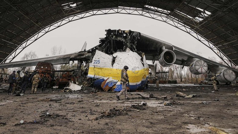 A Ukrainian serviceman walks by an Antonov An-225 Mriya aircraft destroyed during fighting between Russian and Ukrainian forces on the Antonov airport in Hostomel, Ukraine, Saturday, April 2, 2022. At the entrance to Antonov Airport in Hostomel Ukrainian troops manned their positions, a sign they are in full control of the runway that Russia tried to storm in the first days of the war.(AP Photo/Vadim Ghirda)