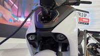 Desain fascia skuter ini mirip moge Yamaha YZF-R1 dengan ciri khas dua buah lampu proyektor dengan posisi ngumpet. Tampak juga di atasnya terdapat port pengisian daya baterai. Foto: Luthfi Anshori/detikOto