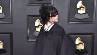 Billie Eilish mengenakan boots dan busana hitam dengan bagian belakang panjang. (Foto: Jordan Strauss/Invision/AP/Jordan Strauss)