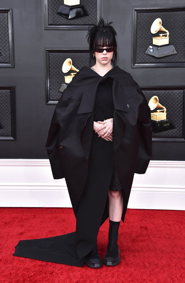 Bukan sesuatu yang mengejutkan bila Billie Eilish tampil serba hitam. Namun, busana dari Rick Owens ini hadir dengan twist unik. Outerwear dibuat seolah-seolah terbalik. (Foto: Jordan Strauss/Invision/AP/Jordan Strauss)