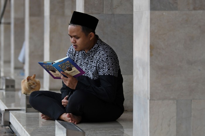 Umat Islam membaca Al Quran di kompleks Masjid Istiqlal, Jakarta, Minggu (3/4/2022). Membaca Al Quran (tadarus)  dilakukan umat Islam untuk meningkatkan ibadah selama bulan suci Ramadhan. ANTARA FOTO/Aditya Pradana Putra/YU
