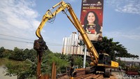 Pekerja mengoperasikan alat berat memperbaiki tanggul turap kali Bekasi yang jebol di Jembatan Rawa Panjang, kota Bekasi, Jawa Barat, Senin (4/4/2022).