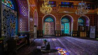 Interior masjid dipenuhi dengan warna kaca patri, lampu gantung kristal dan nuansa warna ungu, kuning emas dan merah marun.
