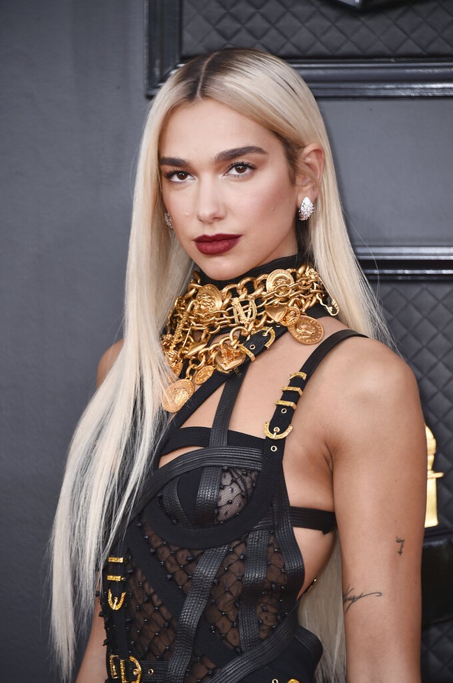 Melangkah di karpet merah Grammy Awards 2022, Dua Lipa memilih tampil seksi mengenakan busana dari Versace. Tak hanya itu saja, Dua Lipa tampaknya juga mengubah gaya rambutnya menjadi rambut panjang lurus berwarna platinum blonde. Foto: Jordan Strauss/Invision/AP