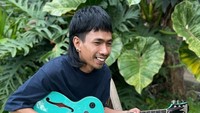 Ketika merancang musik untuk lagunya, lagi-lagi Ari Lesmana memilih segelas kopi untuk dinikmati. Gitar hijau kesayangannya tak pernah lepas dari genggaman untuk menyempurnakan karya-karyanya. Foto: Instagram/ari_lesmana