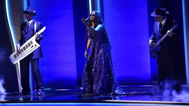 H.E.R., center, performs 