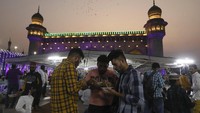 Kebersamaan saat menyantap takjil di depan masjid Mecca, Hyderabad, India, Minggu (3/4/2022). (AP Photo /Mahesh Kumar A.)
