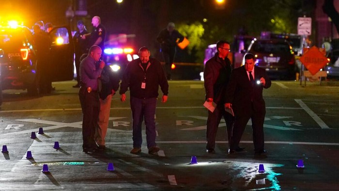 A crime scene investigator photographs evidence markers at the scene of a mass shooting In Sacramento, Calif. April 3, 2022. (AP Photo/Rich Pedroncelli)