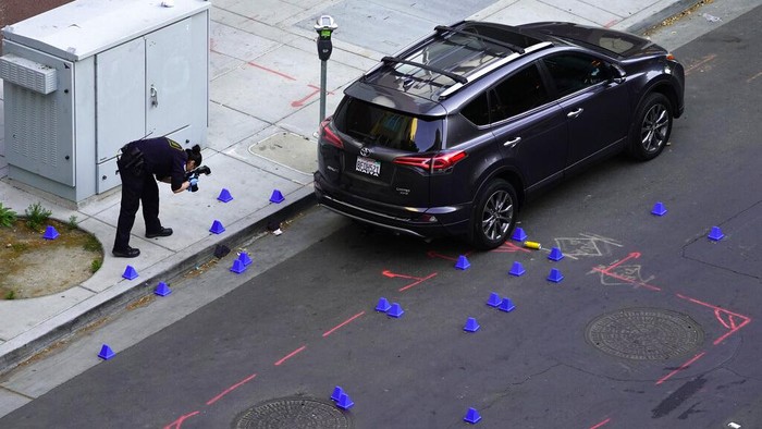 Horor Penembakan di Sacramento California A crime scene investigator photographs evidence markers at the scene of a mass shooting In Sacramento, Calif. April 3, 2022. (AP Photo/Rich Pedroncelli)