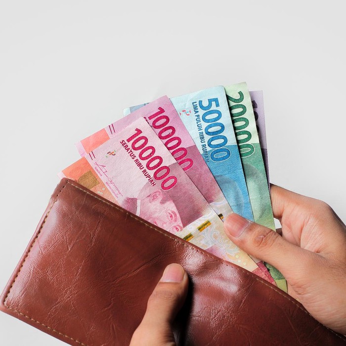 hand showing rupiah money from wallet isolated on white background