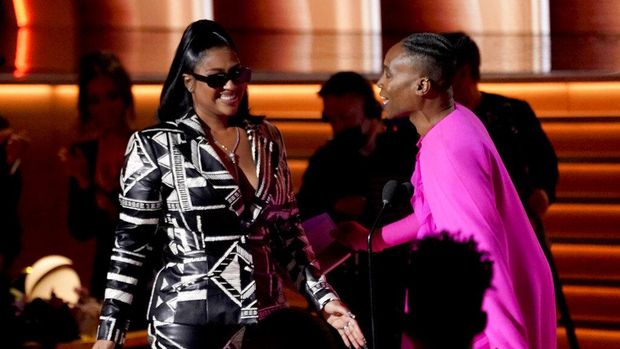 Billy Porter, right, presents Jazmine Sullivan with the award for best R&B album for 