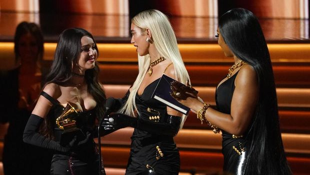 Megan Thee Stallion, right, and Dua Lipa, center, present Olivia Rodrigo with the award for best new artist at the 64th Annual Grammy Awards on Sunday, April 3, 2022, in Las Vegas. (AP Photo/Chris Pizzello)