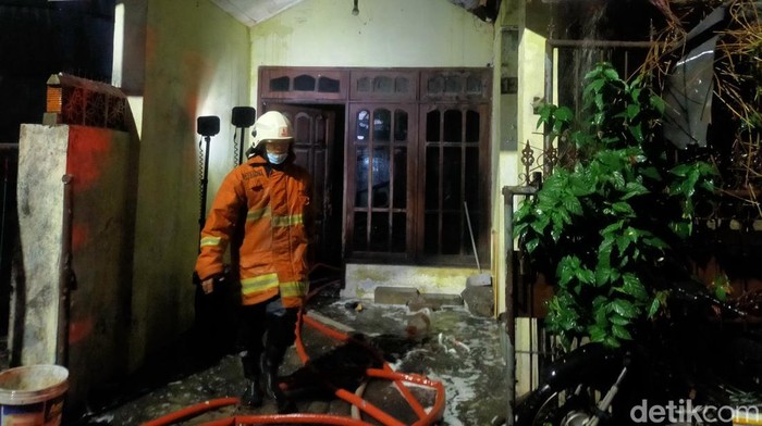 Petugas pemadam kebakaran berbuka puasa setelah memadamkan api di rumah yang ada di lingkungan padat penduduk di Wonocolo.