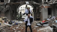 Anastasia dan Anton berpose untuk foto pernikahan mereka (prewedding) di halaman gedung apartemen yang hancur akibat ledakan bom di Kharkiv, Ukraina, Minggu (3/4/2022) waktu setempat. Keduanya terlihat bahagia seperti pasangan pernikahan pada umumnya.