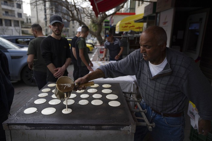 Ramadan Palestinians A Palestinian street vendor bakes Shrak bread, widely desired while breaking fast in Ramadan, in the West Bank city of Ramallah, Saturday, April 2, 2022. The Muslim holy month of Ramadan, when the faithful fast from dawn to dusk, began at sunrise Saturday in much of the Middle East, where Russia's invasion of Ukraine has sent energy and food prices soaring. (AP Photo/Nasser Nasser)