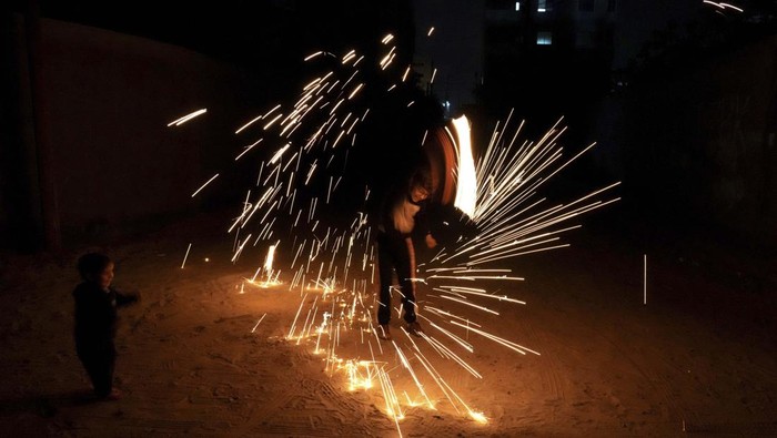 A man swings fireworks during the Muslim holy fasting month of Ramadan, in Gaza City, Saturday, April 2, 2022. (AP Photo/Hatem Moussa)