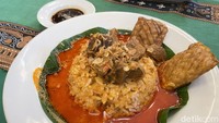 Nasi Gandul seharga Rp 54.000 dari Teras Budhe memiliki tampilan yang agak berbeda. Seporsinya disajikan dengan potongan daging sapi yang cukup besar dan empuk, lalu disiram kuah kemerahan yang kental. Sekilas mirip paduan kuah gulai atau pindang Kudus. Foto: detikFood/Yenny Mustika Sari