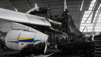 Di badan pesawat Antonov AN-225 ada lubang menganga dan hangus. Sayap raksasanya tersungkur ke tanah, salah satu mesinnya terbakar dan hancur.
