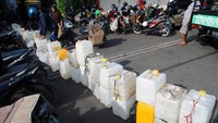 Warga mengantre dengan membawa jeriken yang letakkan berjejer di halaman salah satu distributor di Kelurahan Sindangbarang.