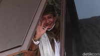 Bahar nampak mengenakan jaket kulit cokelat, sorban putih, kopeah dan bermasker.