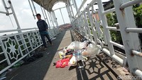 Pejalan kaki melintas diantara sampah yang berada di JPO Kampung Melayu Kecil, Jalan KH Abdullah Syafei, Jakarta Selatan, Selasa (5/4/2022).