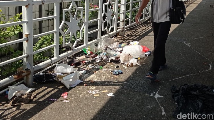 JPO Kampung Melayu Kecil Dipenuhi Sampah Pejalan kaki melintas diantara sampah yang berada di JPO Kampung Melayu Kecil, Jalan KH Abdullah Syafei, Jakarta Selatan, Selasa (5/4/2022).