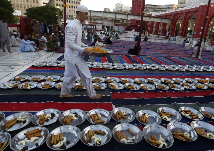 Kebersamaan Berbuka di Pakistan Umat muslim berbuka bersama dengan lesehan di halaman masjid hingga di jalanan Karachi, Pakistan. Kebersamaan terlihat dari penyajian yang egaliter dengan gaya lesehan.