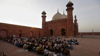 Umat muslim berbuka bersama di halaman Masjid Badashi, Lahore, Pakistan, Minggu (3/4/2022). Masjid tersebut dibangun pada era Kesultanan Mughal, tepatnya saat kepemimpinan Raja Aurangzeb, 1671 Masehi.