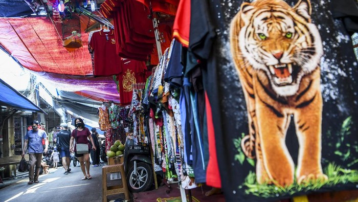 Warga berjalan melintasi lapak pedagang kaki lima (PKL) di kawasan Petak Sembilan, Glodok, Jakarta, Selasa (5/4/2022). Sebanyak 160 PKL di kawasan Petak Sembilan rencananya akan direlokasi ke Pasar Glodok agar jalan tersebut bisa dilalui kendaraan mobil dan motor, sejalan dengan penataan kawasan Kota dalam menyambut Stasiun MRT Taman Sari. ANTARA FOTO/Hafidz Mubarak A/rwa.