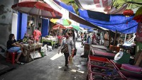 Warga melintasi lapak pedagang kaki lima (PKL) di kawasan Petak Sembilan, Glodok.