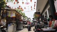 Pengendara motor melintas di dekat lapak pedagang kaki lima (PKL) di kawasan Petak Sembilan, Glodok.