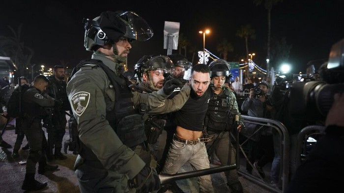 Polisi Israel-Warga Palestina Bentrok di Kota Tua saat Ramadan Israeli border police officers detain a protester during clashes between Israeli security forces and Palestinians next to Damascus Gate, outside the Old City of Jerusalem, during the Muslim holy month of Ramadan, Monday, April 4, 2022. (AP Photo/Mahmoud Illean)