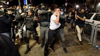 Tampak dua polisi Israel menggiring seorang warga Palestina yang ditangkap. (Ammar Awad/Reuters)