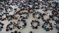 Ribuan santri membuat kelompok dan lingkaran saat membaca Al-Quran bersama.