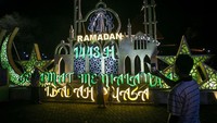 Warga berfoto dengan latar belakang instalasi lampion bertema Ramadhan di kawasan Balai Kota, Solo, Jawa Tengah, Selasa (5/4/2022).