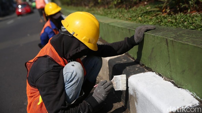 Pekerja melakukan pengecetan separator di Jalan Cut Mutia, Kota Bekasi, Jawa Barat, Selasa (4/4/2022).