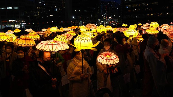 South Korean Buddhist monks wearing face masks, carry colorful lotus lanterns during the lighting ceremony to celebrate for the upcoming birthday of Buddha on May 8, in Seoul, South Korea, Tuesday, April 5, 2022. (AP Photo/Lee Jin-man)